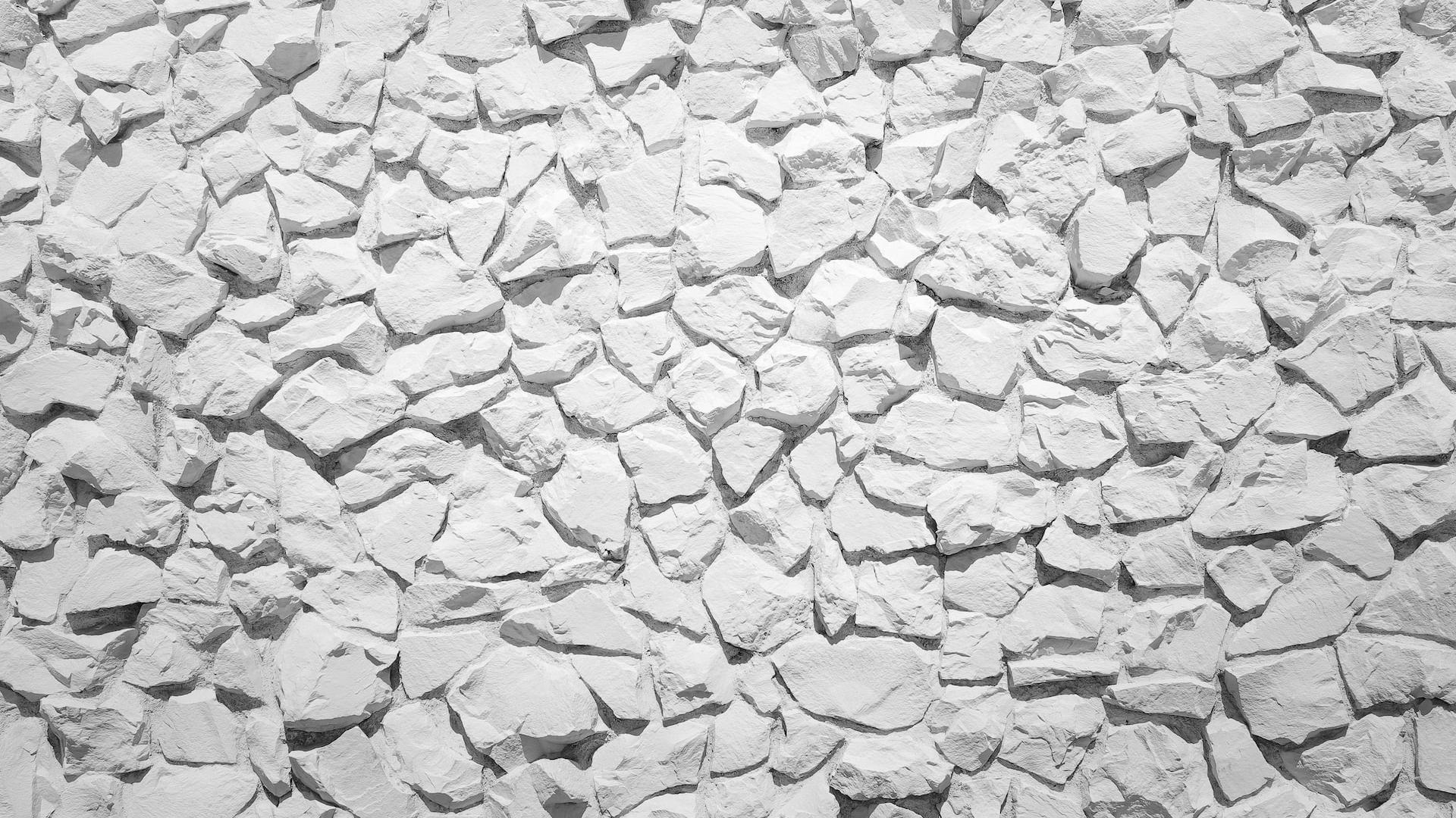 a white stone wall with small rocks on it